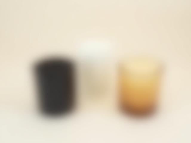 A 'Minimalist Trio' bundle of three TIMOTHY C BUCKLEY candles in matte black, white, and amber vessels.